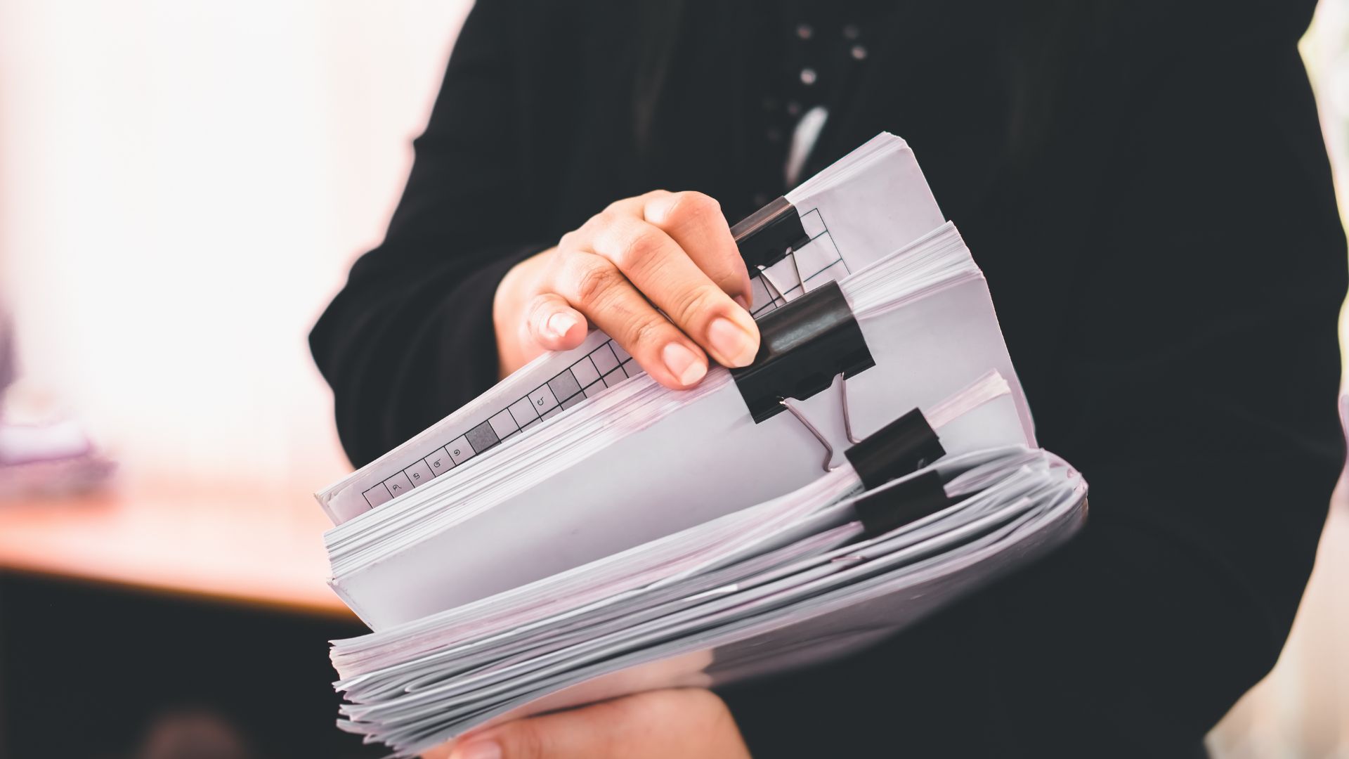 A Legal Nurse Consultant doing a merit review on a stack of medical charts