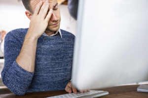 Stressed independent LNC dealing with business struggles on his computer. 